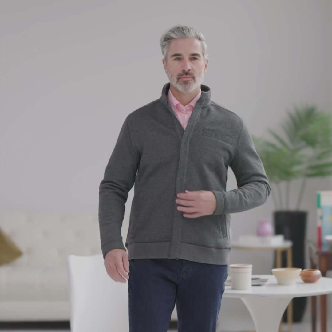 Man wearing a charcoal knit fleece Dillon jacket with magnetic closures, showcasing adaptive fashion and comfort.