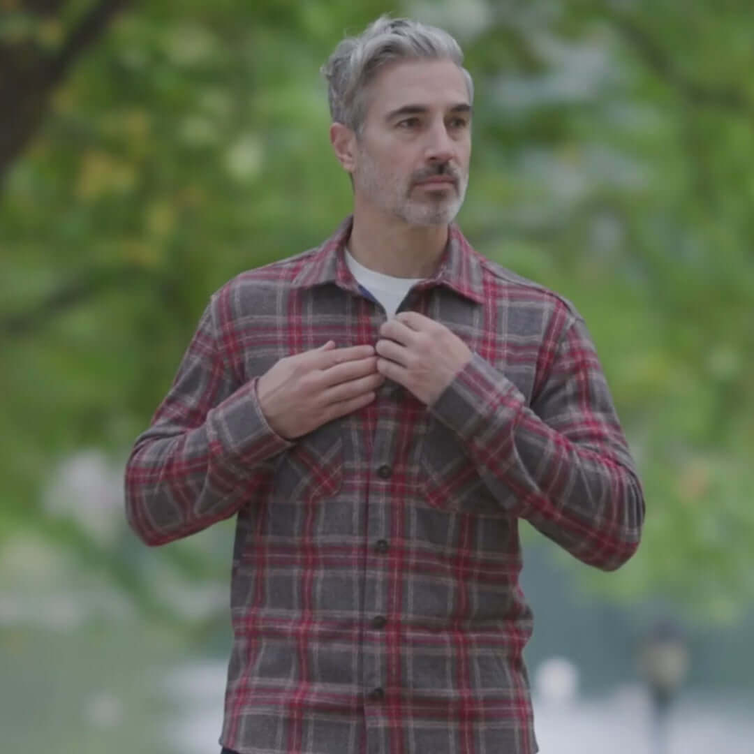 Man wearing an adaptive brown glen plaid flannel shirt outdoors, showcasing style and versatility.