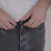 Person adjusting the magnetic fly on black wash five pocket adaptive jeans for easier dressing.
