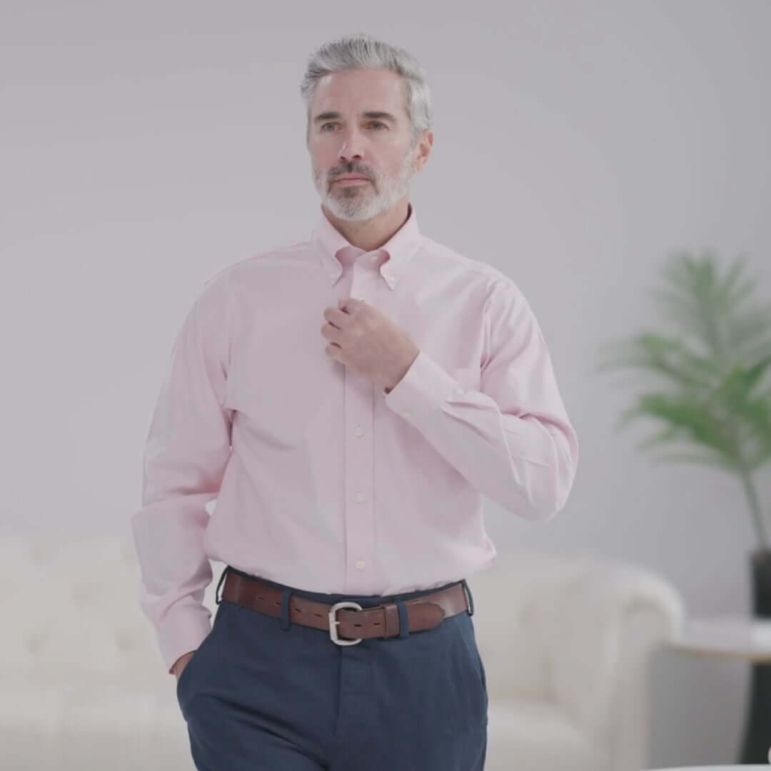 Man wearing a Brooks Brothers X MagnaReady pink polo with button-down collar, showcasing adaptive technology.