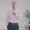Man wearing a Brooks Brothers X MagnaReady pink polo with button-down collar, showcasing adaptive technology.
