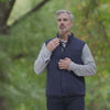 Man in navy diamond quilted magnetic vest outdoors, showcasing stylish adaptive wear for comfort and elegance.