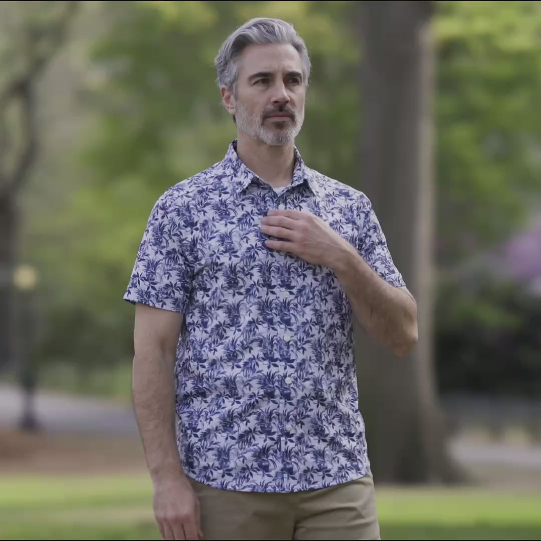 Adaptive Cooling Magnetic Front Short Sleeve Shirt in Blue Grey Palm worn outdoors by a man.
