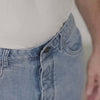 Light wash five pocket jeans with magnetic closures for easy dressing and accessibility.