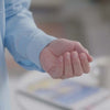 Close-up of a hand in a Carolina Blue long sleeve shirt, demonstrating ease of use and comfort in magnetic button design.