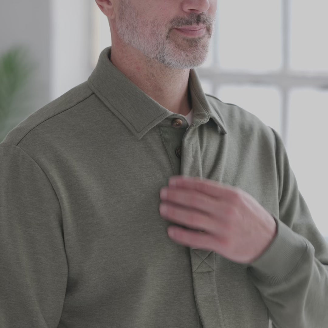 The Adaptive Magnetic Front Sweatshirt in Heathered Olive featuring a man adjusting the collar for comfort.