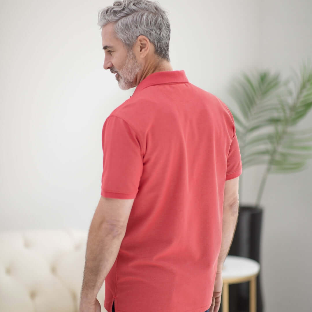 Back view of a man wearing a red heather pique knit polo shirt with magnetic closures, showcasing its comfort and style.