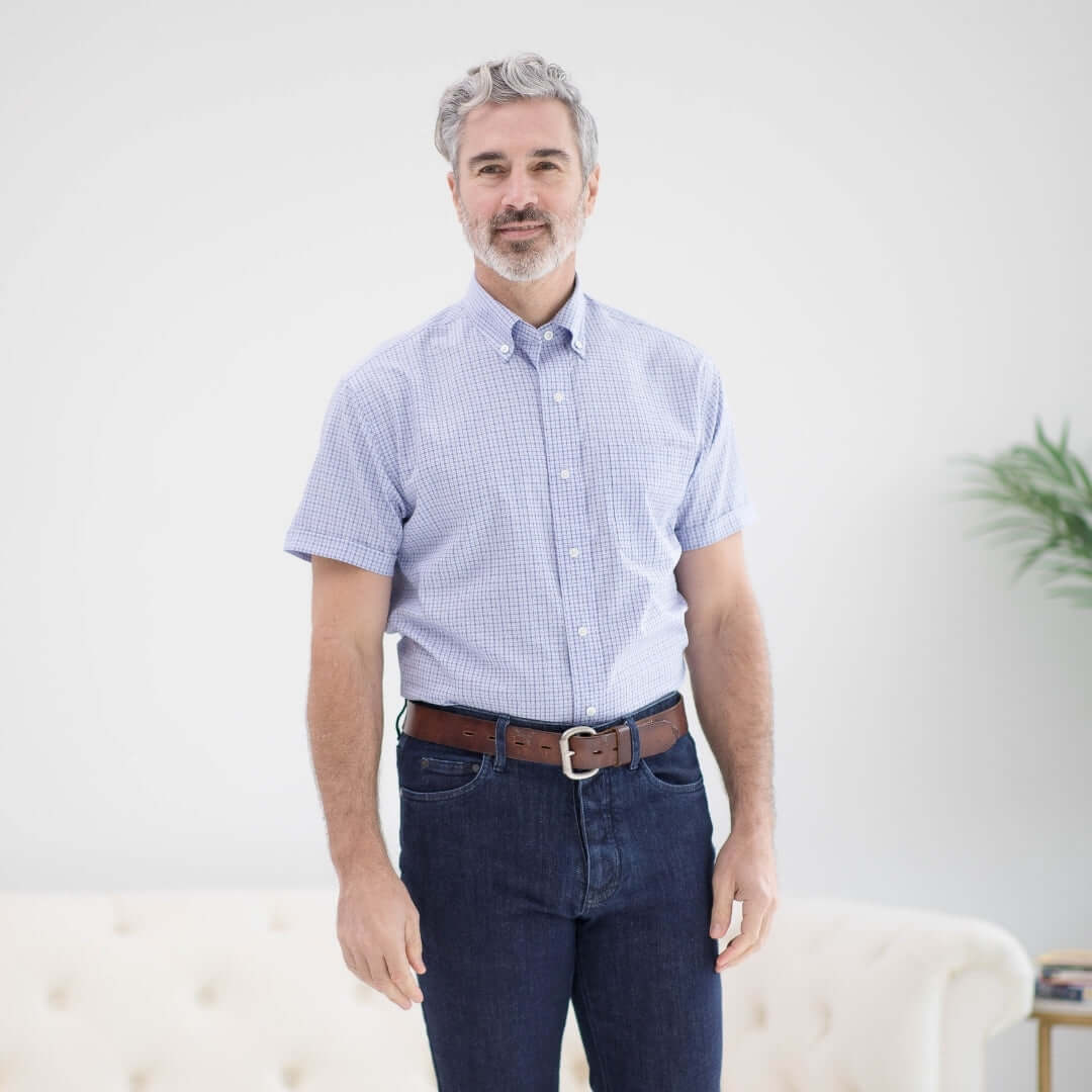 Man wearing a short sleeve blue and red check cotton shirt, featuring a button-down collar, styled with dark jeans.