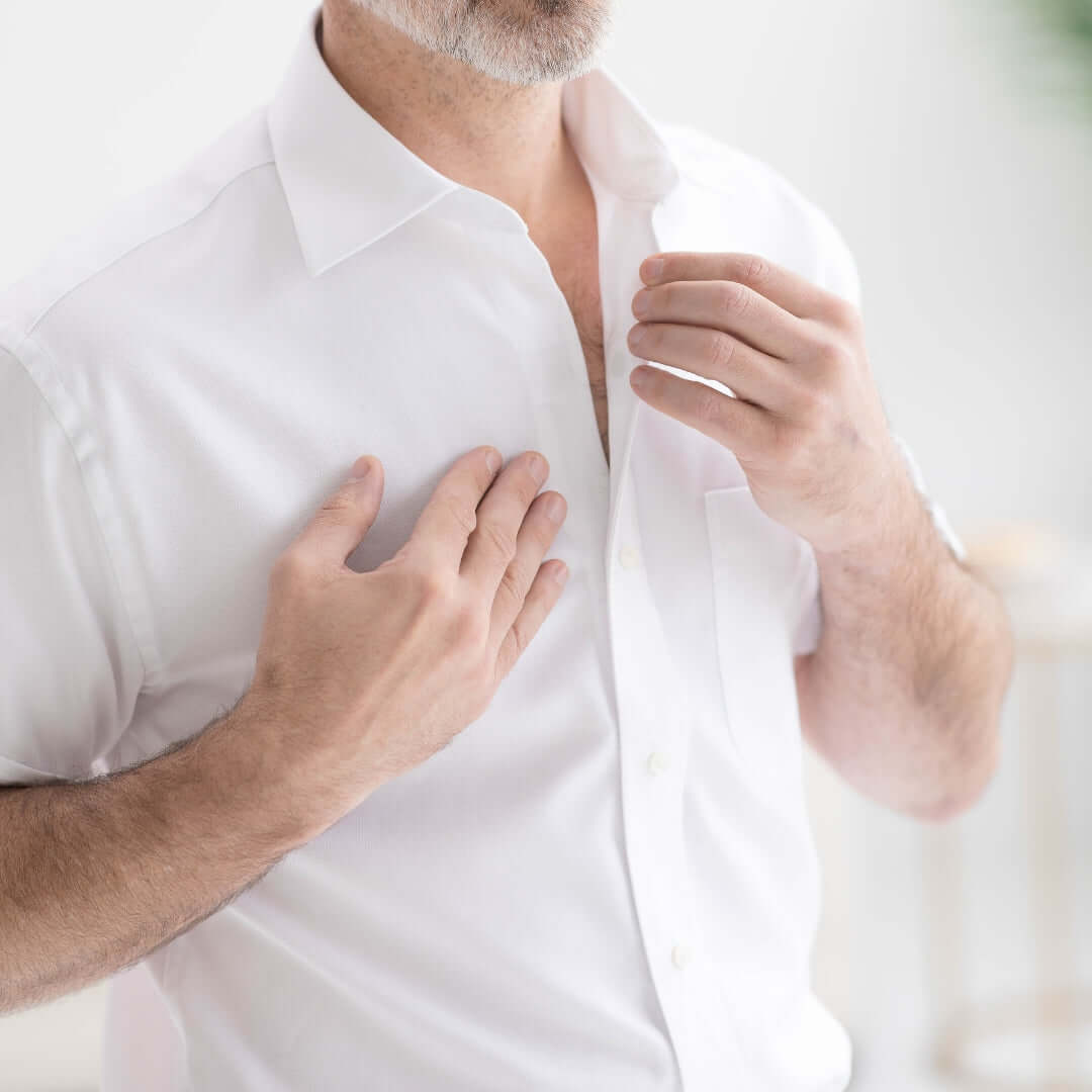 Man adjusting his short sleeve solid white Ryan spread collar shirt with magnetic closures.