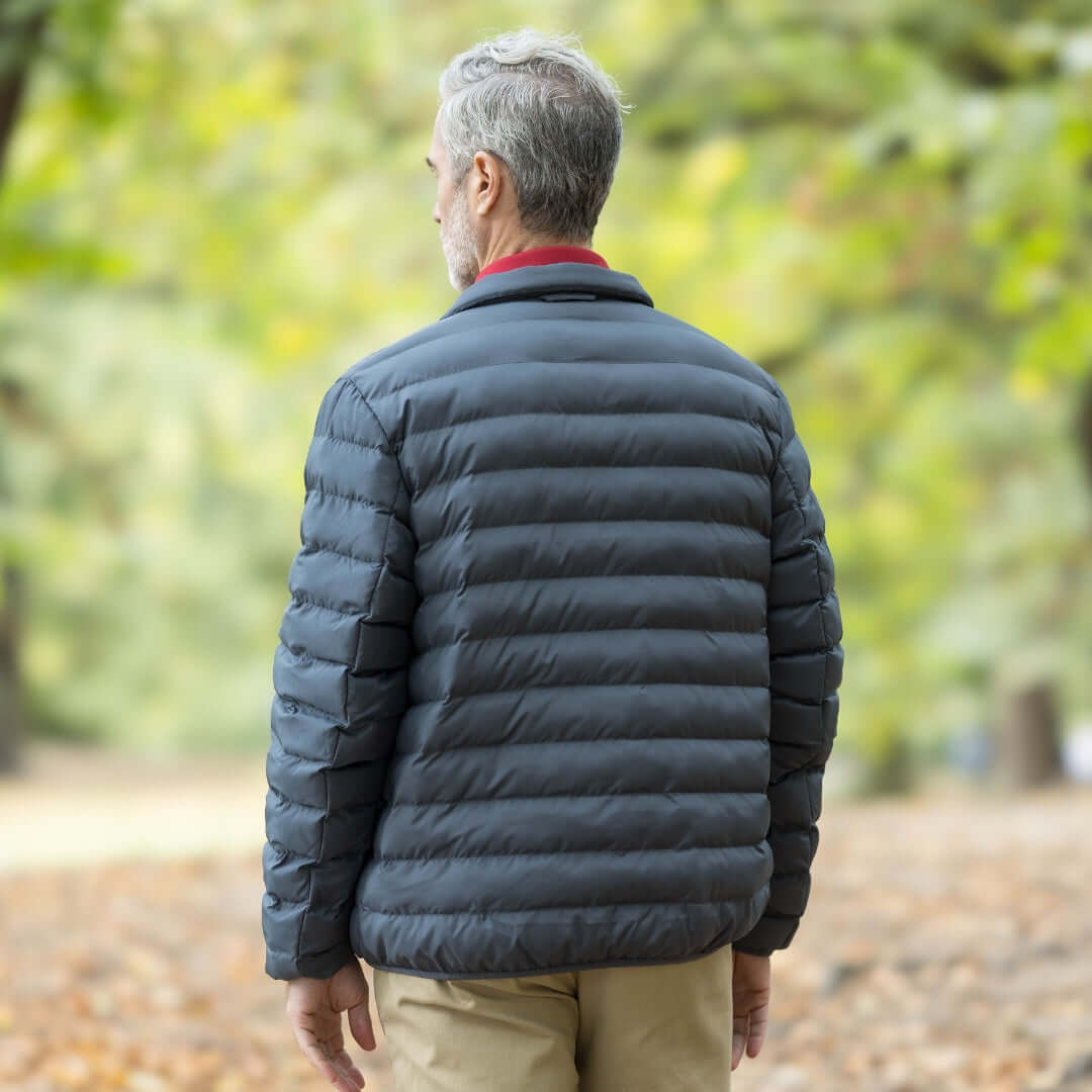 Rear view of man wearing Weatherproof x MagnaReady magnetic puffer jacket in pewter, showcasing its stylish design.