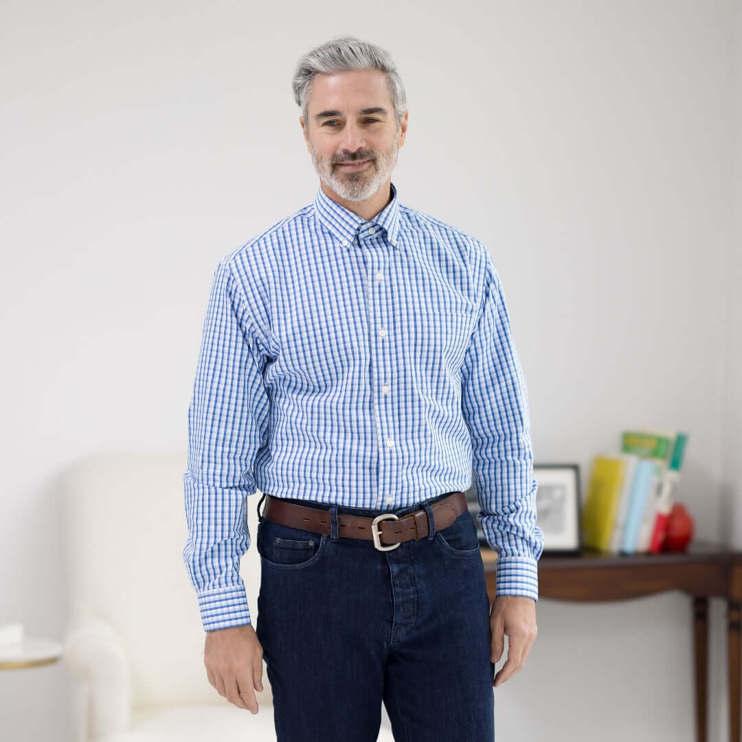 Man wearing a White and Blue Plaid Long Sleeve Button Down Collar Shirt with Magnetic Closures, standing in a bright room.