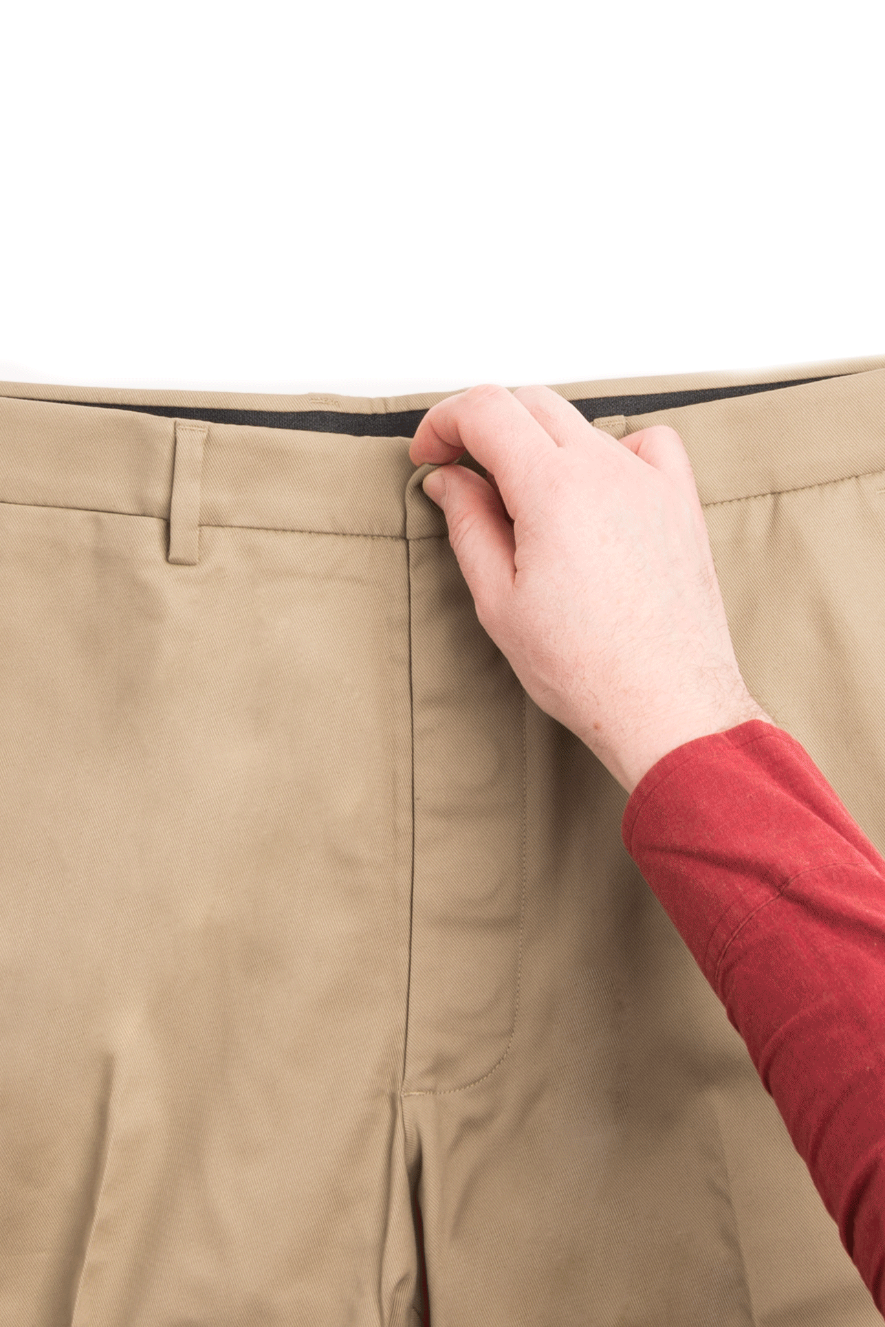 Person demonstrating the magnetic closure of adaptive khaki chino pants for ease of wear.